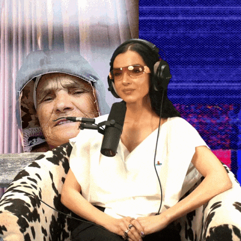 a woman wearing headphones talks into a microphone next to an older woman