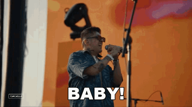 a man singing into a microphone with the word baby written on the bottom
