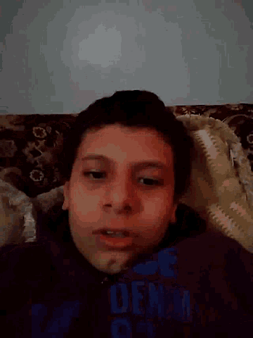a boy wearing a shirt that says denim looks at the camera