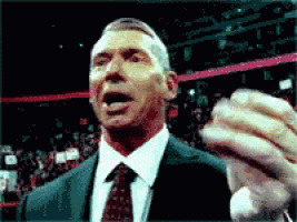 a man in a suit and tie holds his hand up in the air