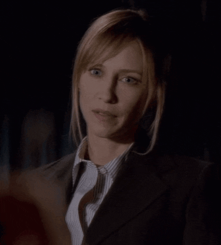 a woman in a suit and tie is making a silly face