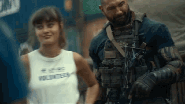 a man and a woman are standing next to each other and the woman is wearing a volunteer shirt