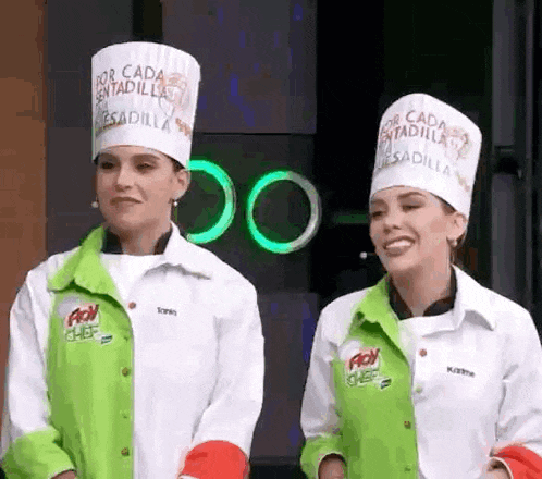 two women wearing chef hats that say " por cada sentadilla " are standing next to each other