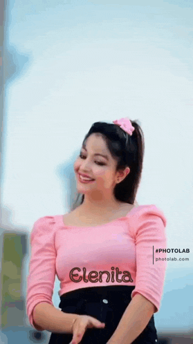 a woman is wearing a pink top with the name elenita on it .