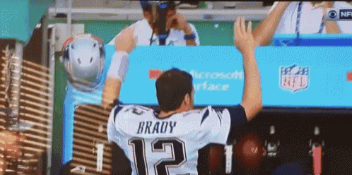 a man in a brady jersey stands in front of a microsoft advertisement