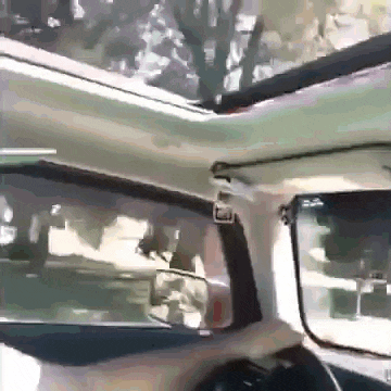the inside of a car with the roof open and a rear view mirror
