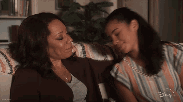 two women sitting on a couch with a disney+ logo on the bottom