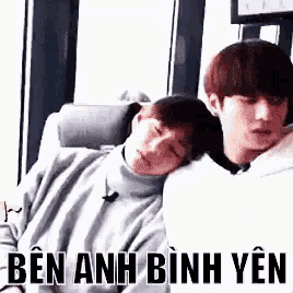 two young men are sitting next to each other on a couch and one of them is sleeping on the other 's shoulder .
