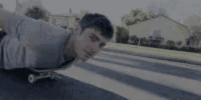 a young man is riding a skateboard down the street .