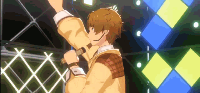 a man is singing into a microphone on a stage in front of a wall of squares .
