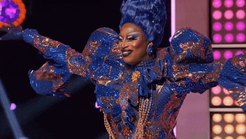 a drag queen is dancing on a stage in a blue and gold costume .