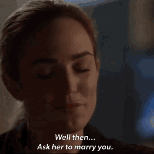 a woman in a dark room says " well then ask her to marry you "