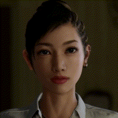 a close up of a woman 's face with a necklace that says ' ? ' on it