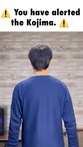 a man in a blue shirt stands in front of a sign that says you have alerted the kojima ..