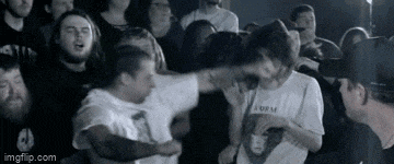 a group of people are standing in a dark room and one of them is wearing a shirt that says norm .
