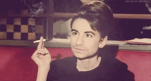 a man is smoking a cigarette in a restaurant while looking at the camera .