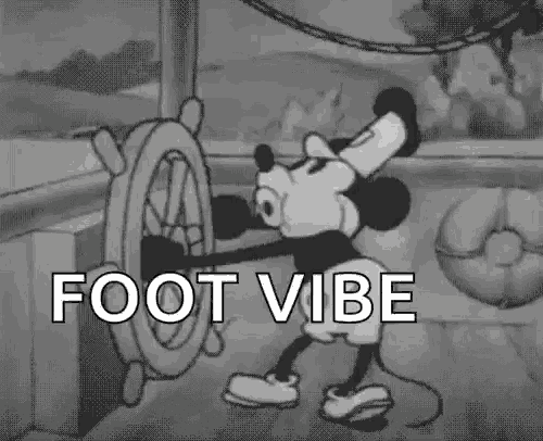 a black and white cartoon of mickey mouse holding the steering wheel with the words foot vibe below him