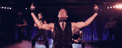 a group of men are dancing on a stage with their arms outstretched .