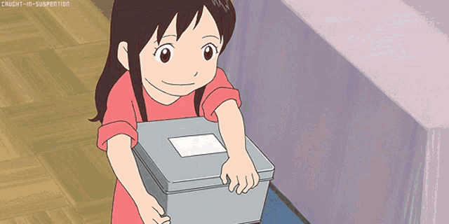 a girl in a pink shirt is holding a box with a white label on it