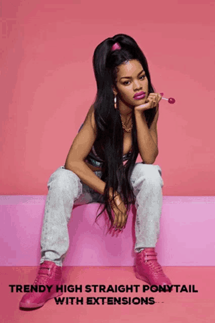 a woman is sitting on a pink block with a lollipop in her hand and the words trendy high straight ponytail with extensions