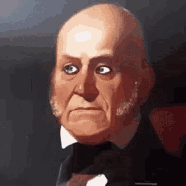 a man in a tuxedo and bow tie is making a funny face