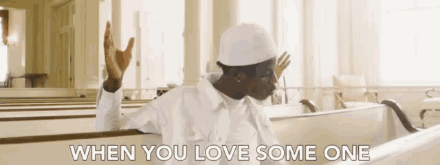 a man is sitting in a church with the words when you love some one