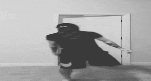 a black and white photo of a man dancing in a room