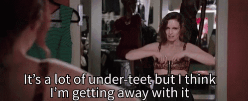 a woman in a leopard print bra is looking at herself in a mirror and says it 's a lot of under teet