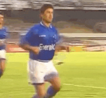 a man is running on a soccer field wearing a blue shirt that says energik .