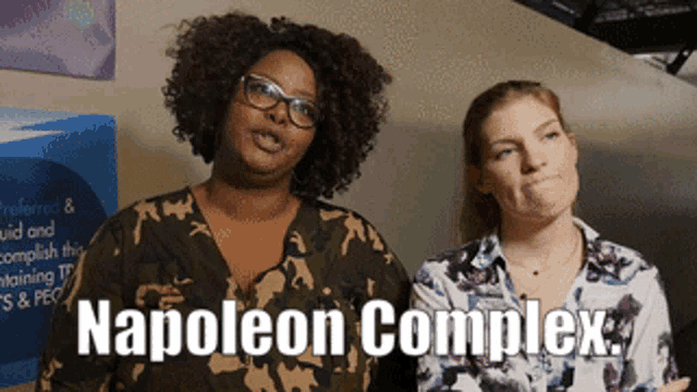 two women standing next to each other with napoleon complex written on the bottom right
