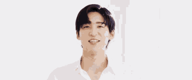 a man with black hair and a white shirt is smiling with his eyes closed .
