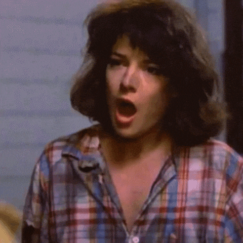 a woman is wearing a plaid shirt with her mouth open .