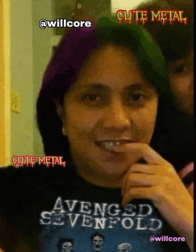 a woman wearing an avenged sevenfold shirt is smiling