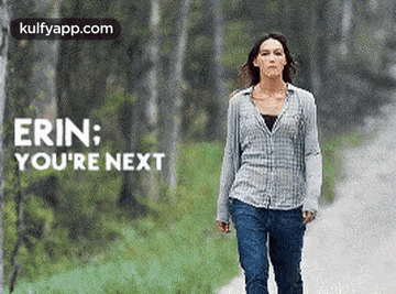 a woman is walking down a road with the words `` erin : you 're next '' on the bottom .