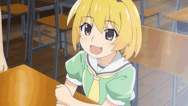 a girl with yellow hair sits at a desk with her mouth open