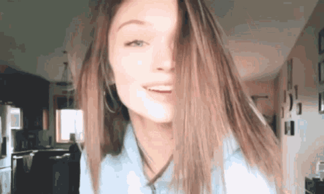a woman with long hair is smiling and looking at the camera .