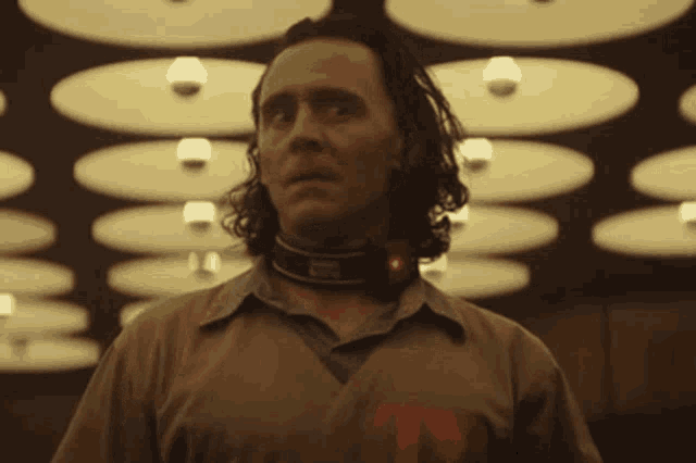 a man with a collar around his neck has the letter t on his chest