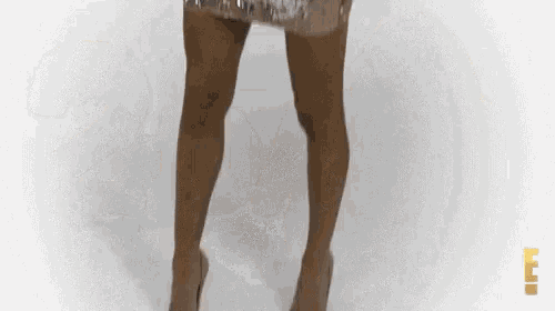 a woman is wearing a sequined dress and heels .