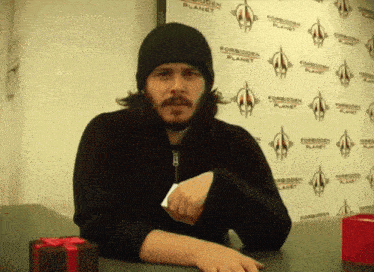 a man sitting in front of a wall with forbidden planet written on it