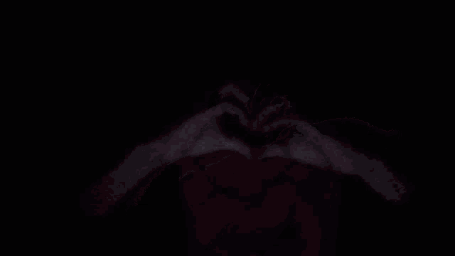 a person is laying on a bed in the dark with a red blanket