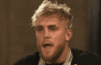 a man with blonde hair and a beard is wearing a black shirt and a chain around his neck .