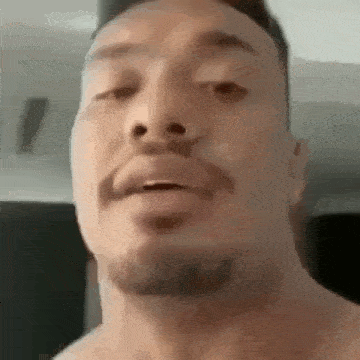 a man with a beard is making a funny face in a close up of his face .