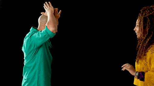 a man in a green shirt and a woman in a yellow sweater are dancing
