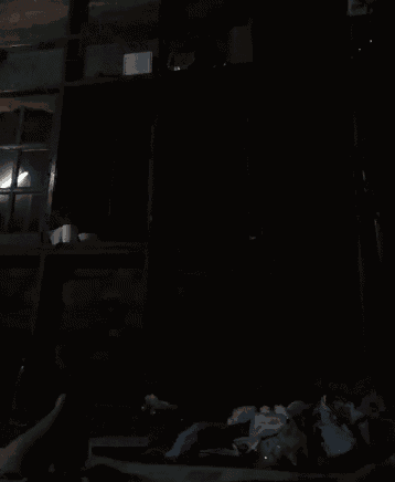 a dark room with a light shining through a window .