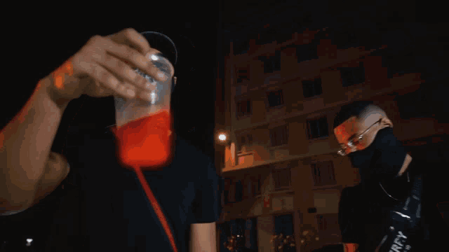 a man wearing a mask is pouring a red liquid into a cup