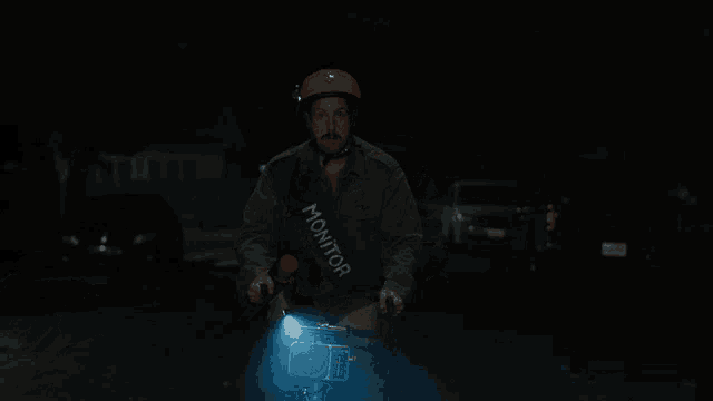 a man wearing a red helmet is holding a flashlight in his hand
