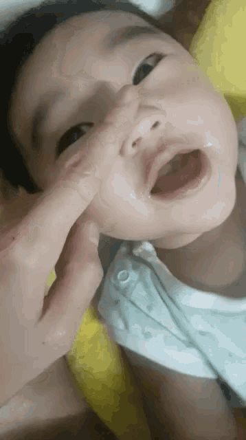 a baby 's nose is being touched by a person