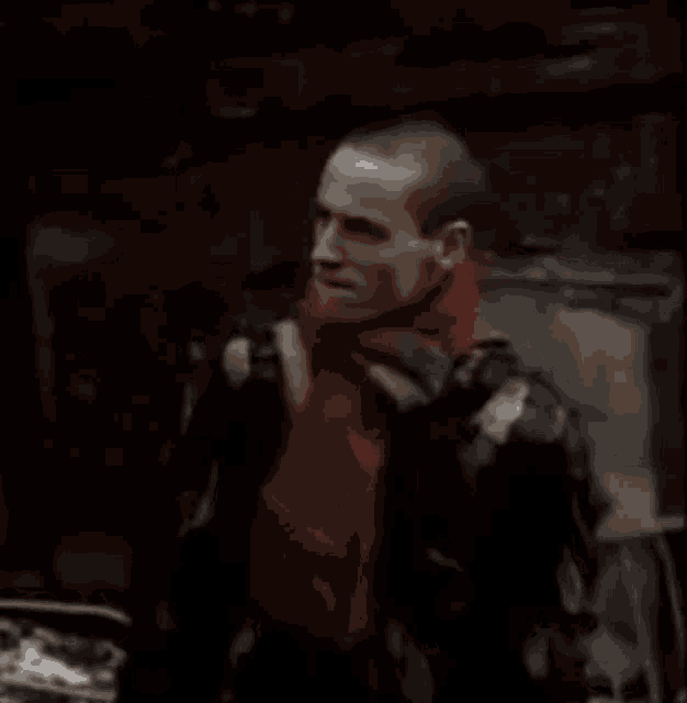 a man in a red hoodie is looking down at something .