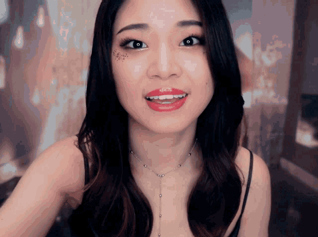 a woman wearing red lipstick and a silver necklace