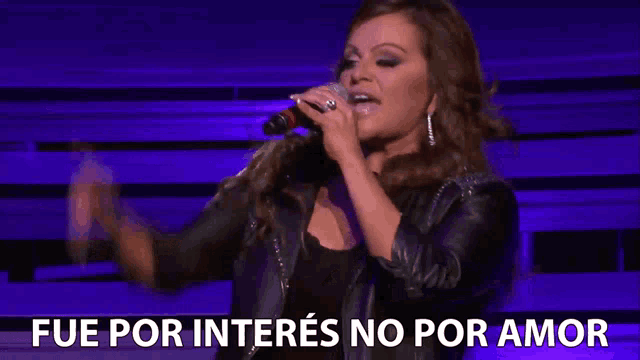 a woman singing into a microphone with fue por intereses no por amor written below her